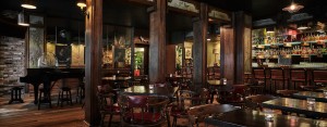 Wooden chairs and small tables in the dimly lit Bayou Bar in New Orleans