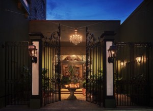 Gate leading to the courtyard with an outdoor chandelier suspended above at the Pontchartrain Hotel
