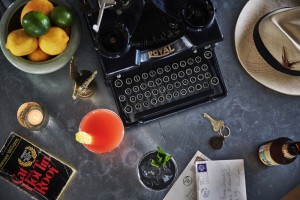 Classic book, old typewriter, key, lemons & limes on a table at our New Orleans hotel