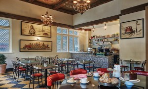 Wide view of the Silver Whistle with art work on the walls and table with coffee and pastries set