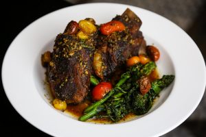 Veal ribs with greens and tomatoes at our NOLA hotel's restaurant