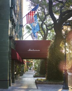 Exterior entrance of the Pontchartrain hotel with the American flag above the awning