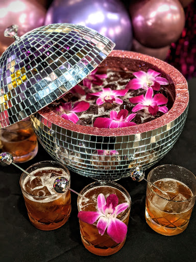 Disco ball cut I half and holding punch with pink flowers in it at our St. Charles hotel in New Orleans
