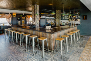 Bar with wooden and steel stools at Hot Tin bar in New Orleans