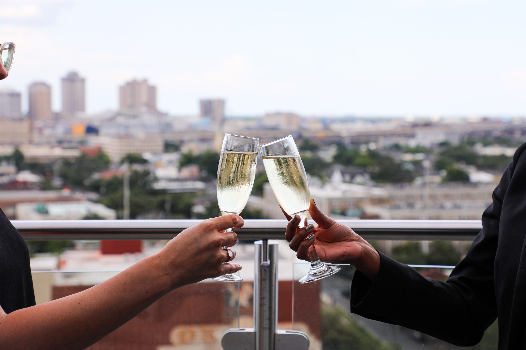 Clinking Champagne glasses on a rooftop overlooking New Orleans
